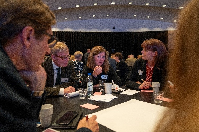 Runda-borden-diskussioner. Närbild på kvinnor och män som lyssnar på varandra under en diskussion runt ett bord.